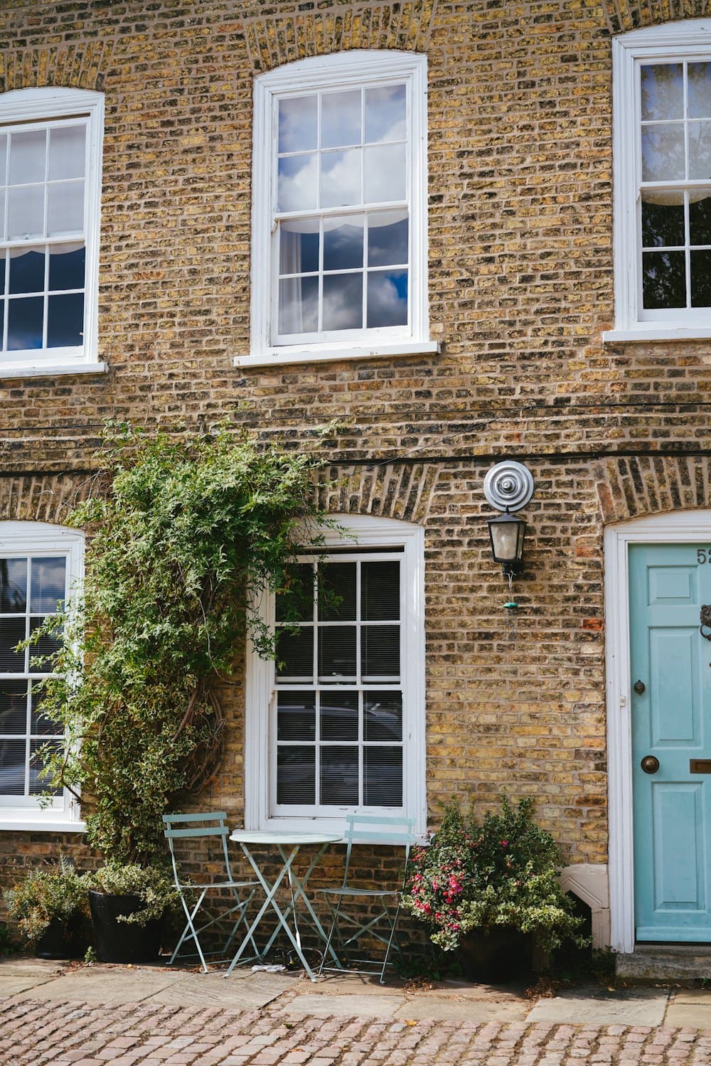 The front of a traditional brick house with a pale blue door